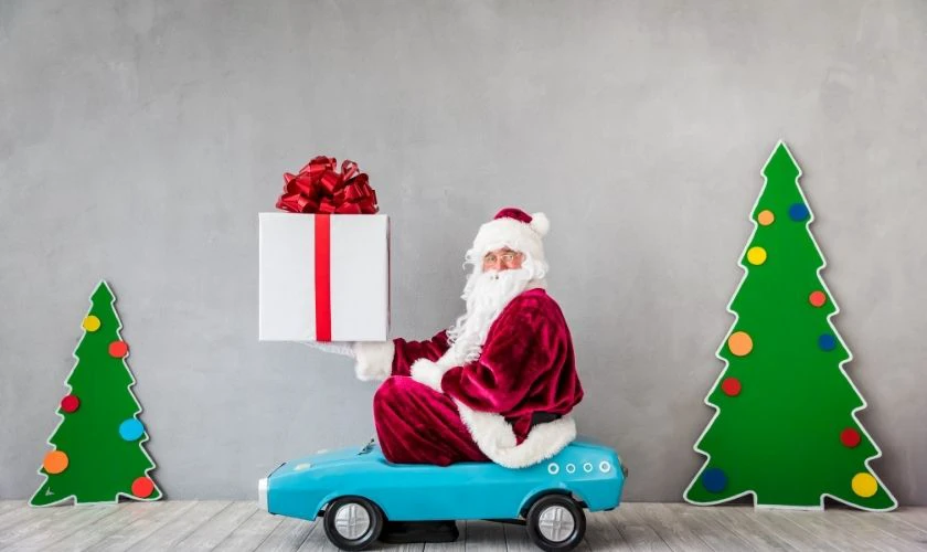 Santa Claus cưỡi ô tô nhí đi tặng quà